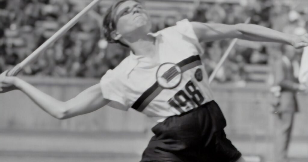 Athlete performing a javelin throw at a track and field event